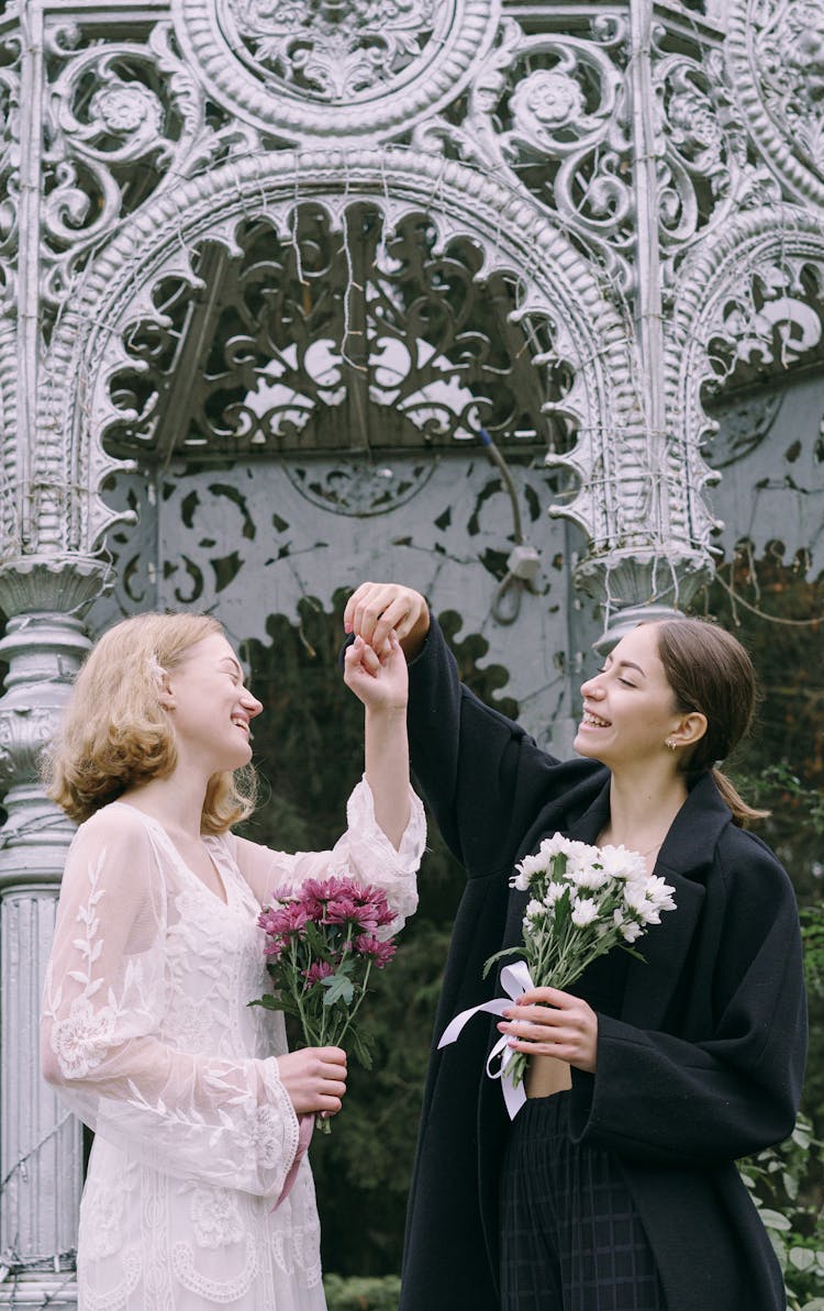 A Happy Couple Holding Flowers