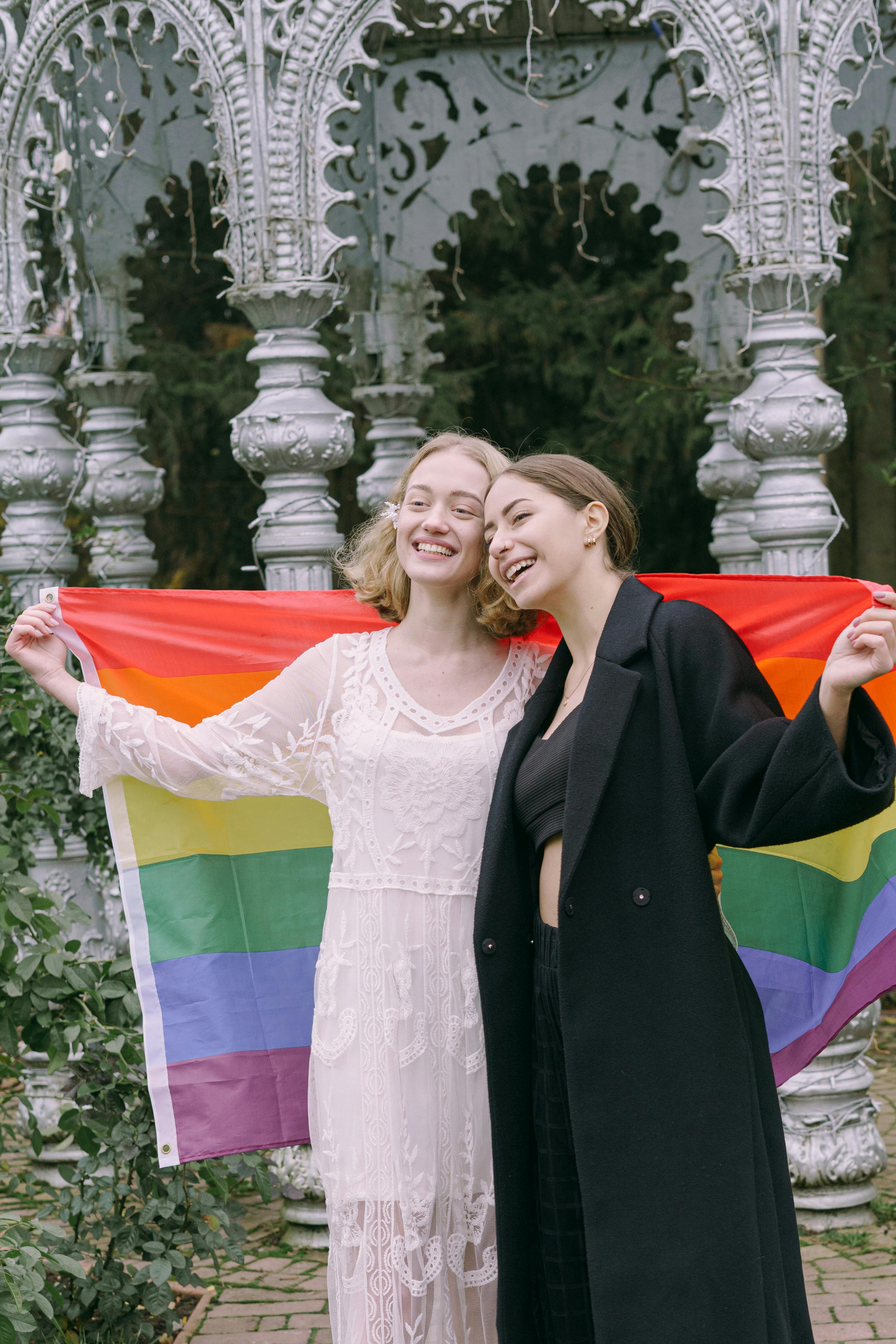 a happy couple holding a rainbow flag