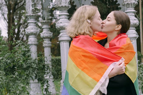 Women Wrapped with Rainbow Flag Kissing