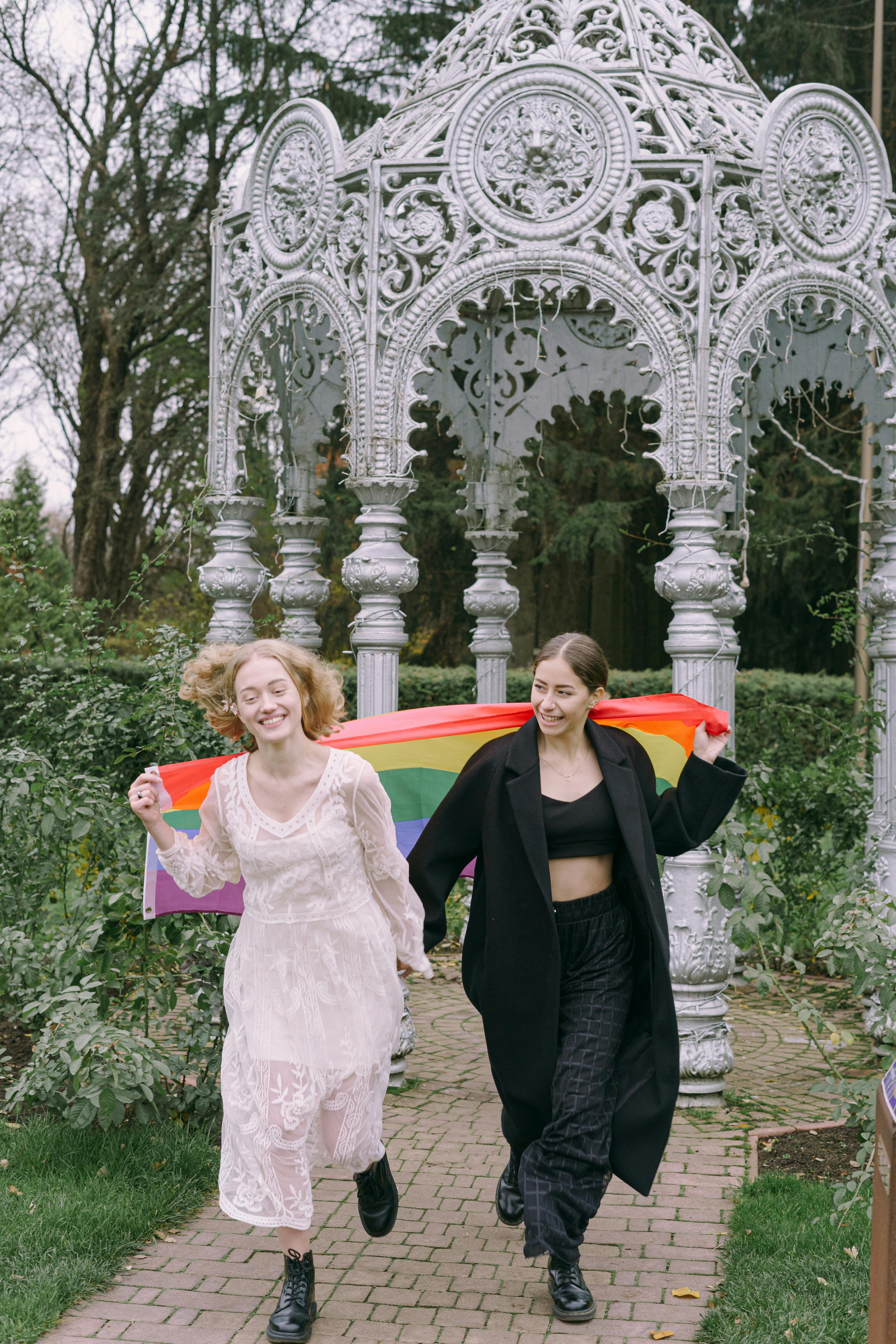 happy couple walking together with gay pride flag