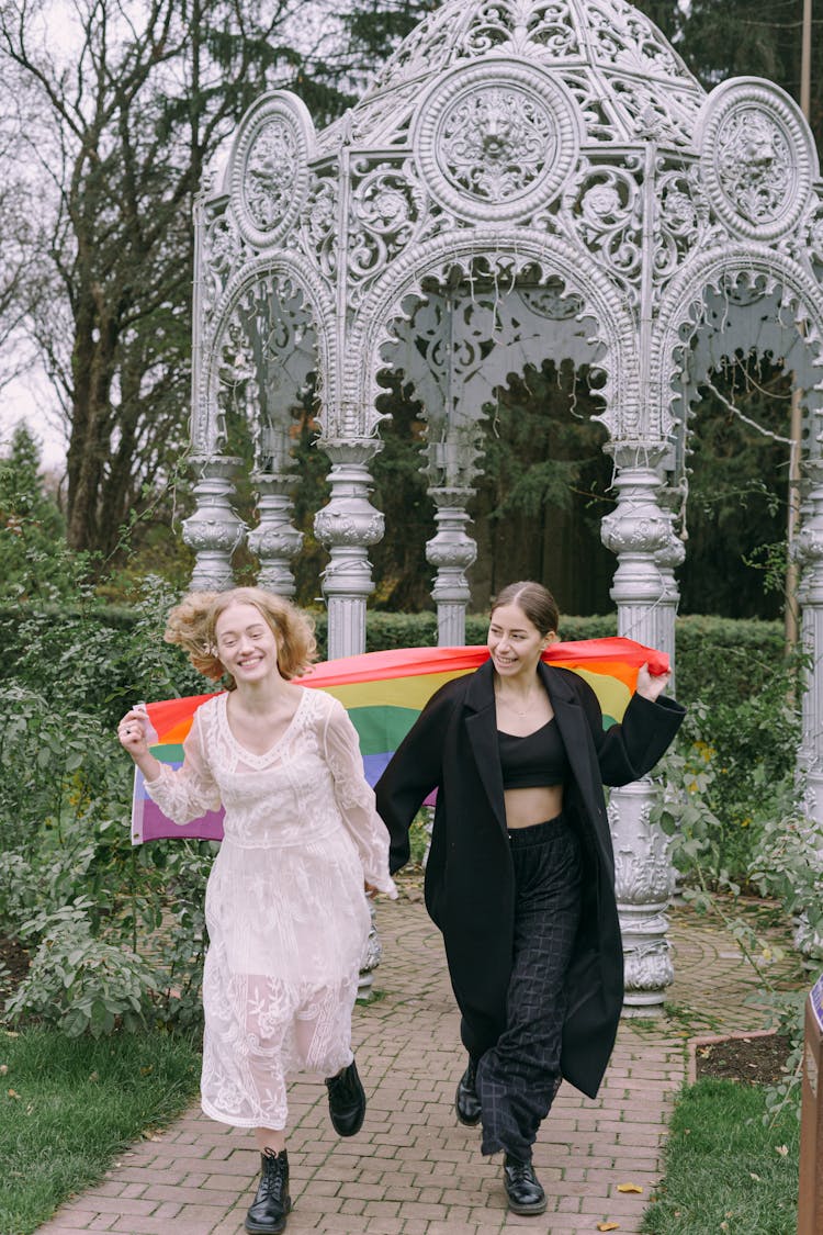 Happy Couple Walking Together With Gay Pride Flag 