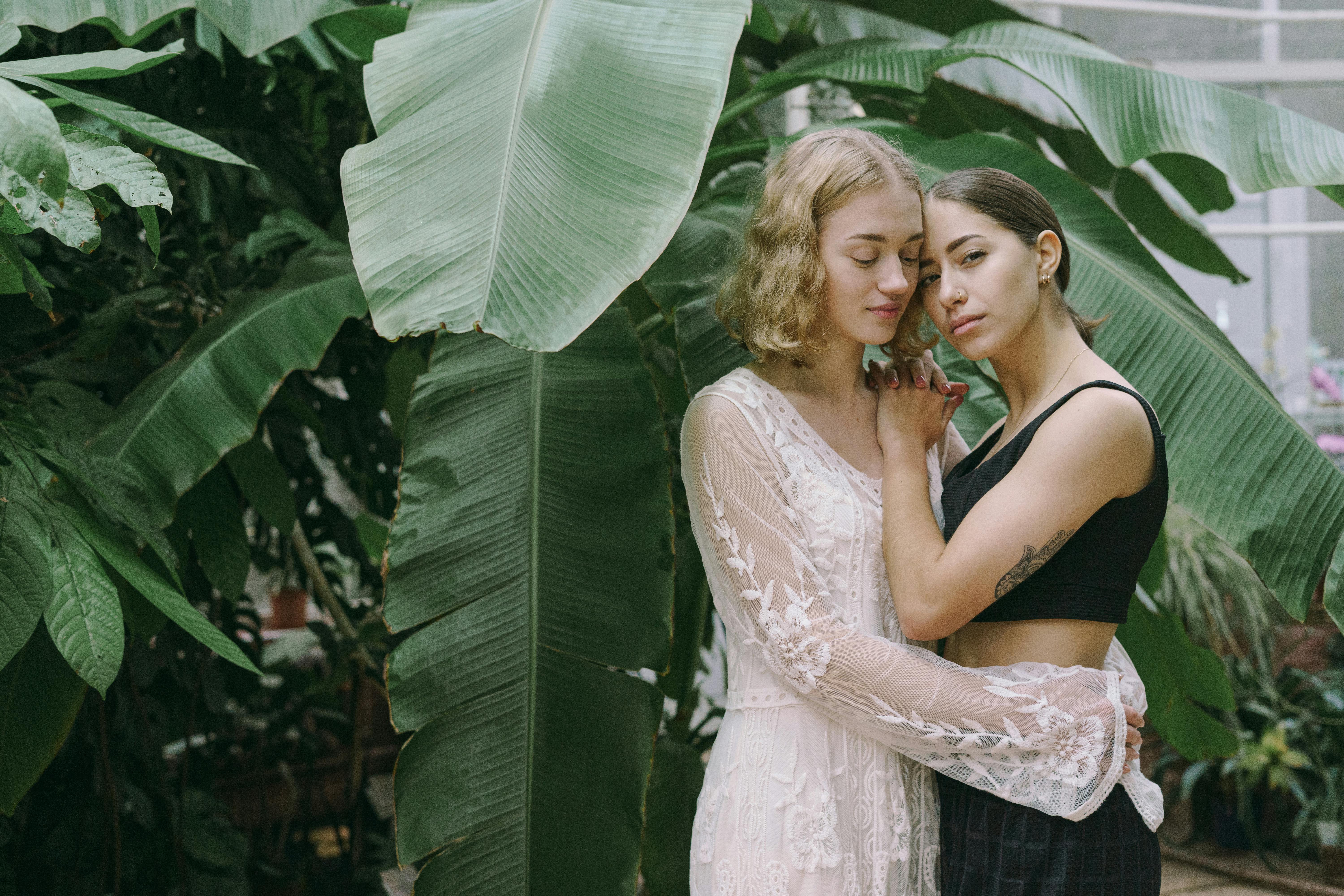 woman in white lace dress beside woman in white floral dress