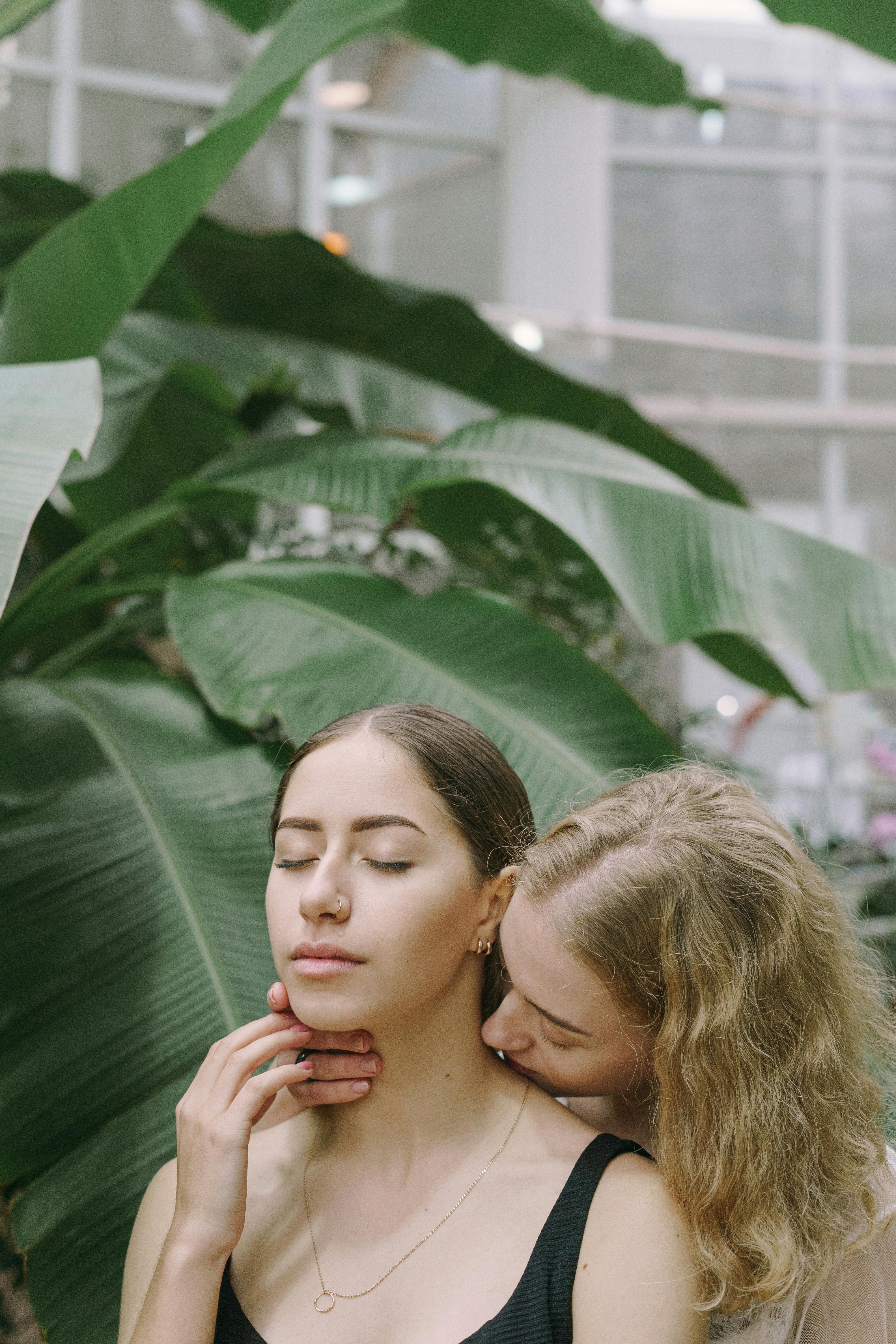 a blonde haired woman kissing her partner on the neck