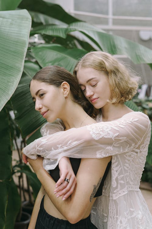 Free Women Embracing Near Green Plants Stock Photo