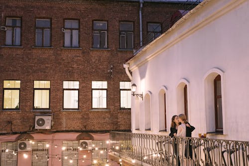 A Same Sex Couple Kissing at the Balcony