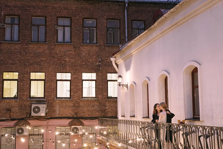 A Same Sex Couple Kissing At The Balcony