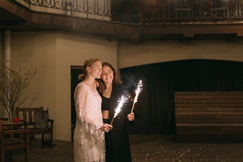 Woman in White Long Sleeve Dress Holding a Stick