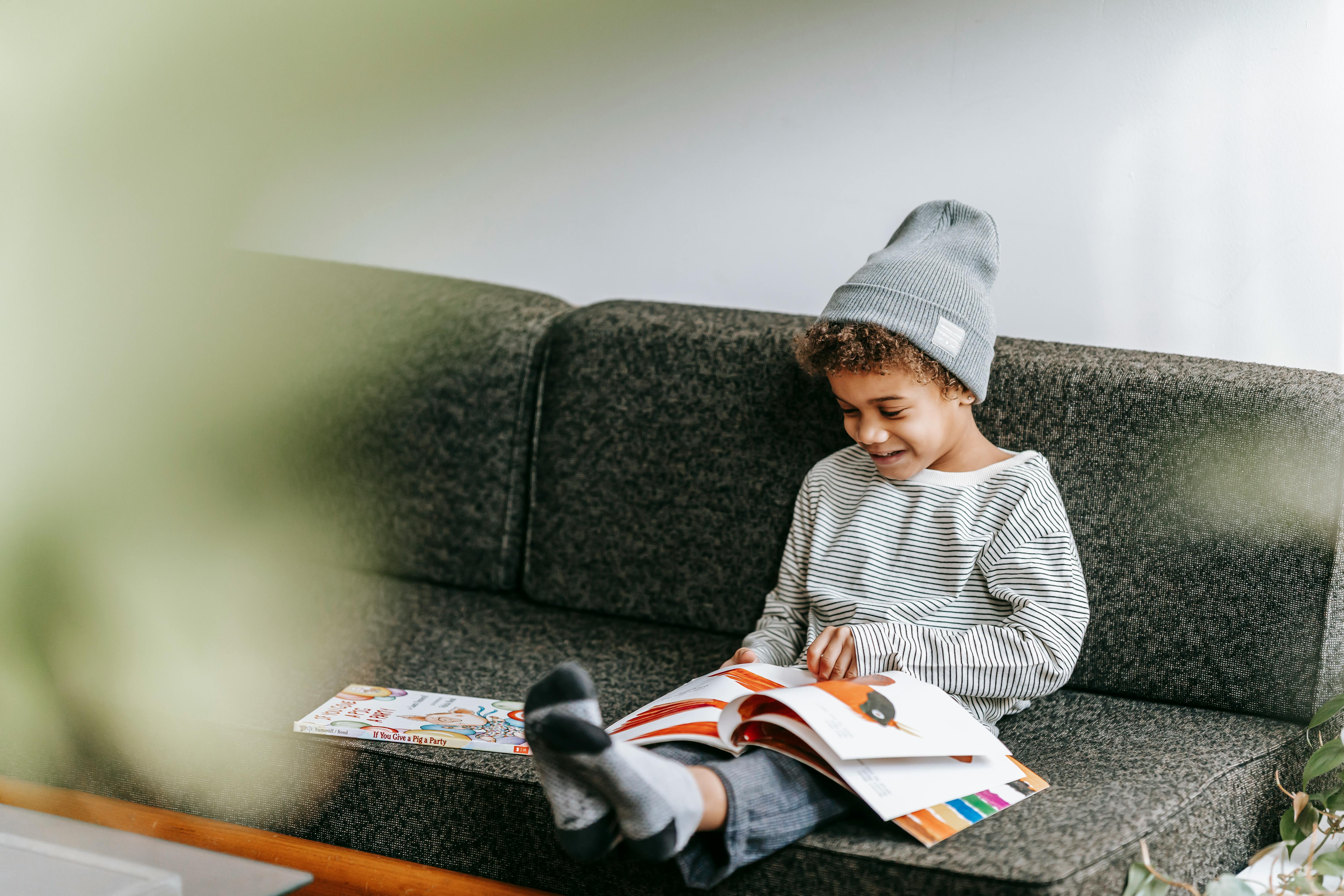 positive black boy reading fairytale with bright pictures