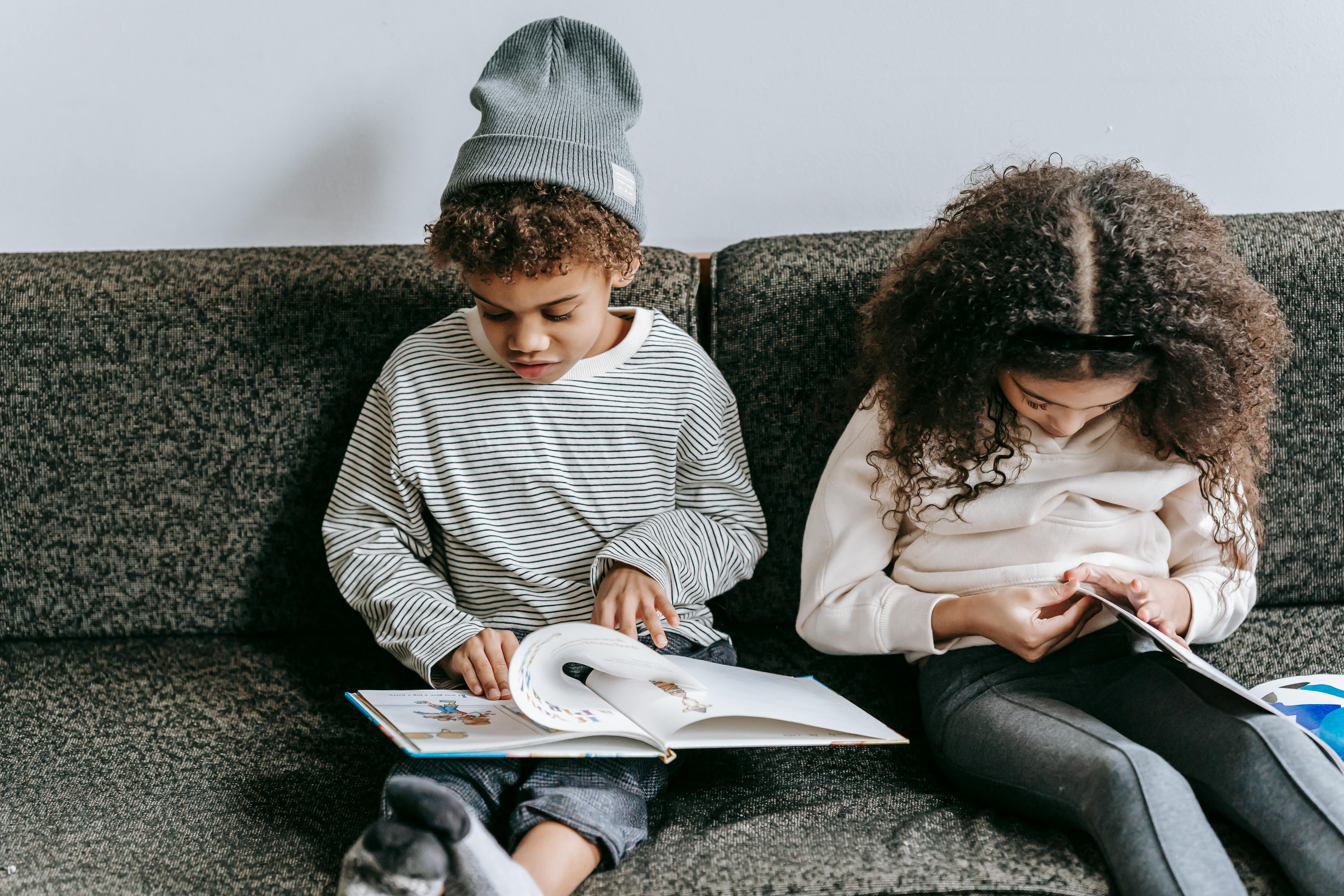 little clever black friends studying books on sofa