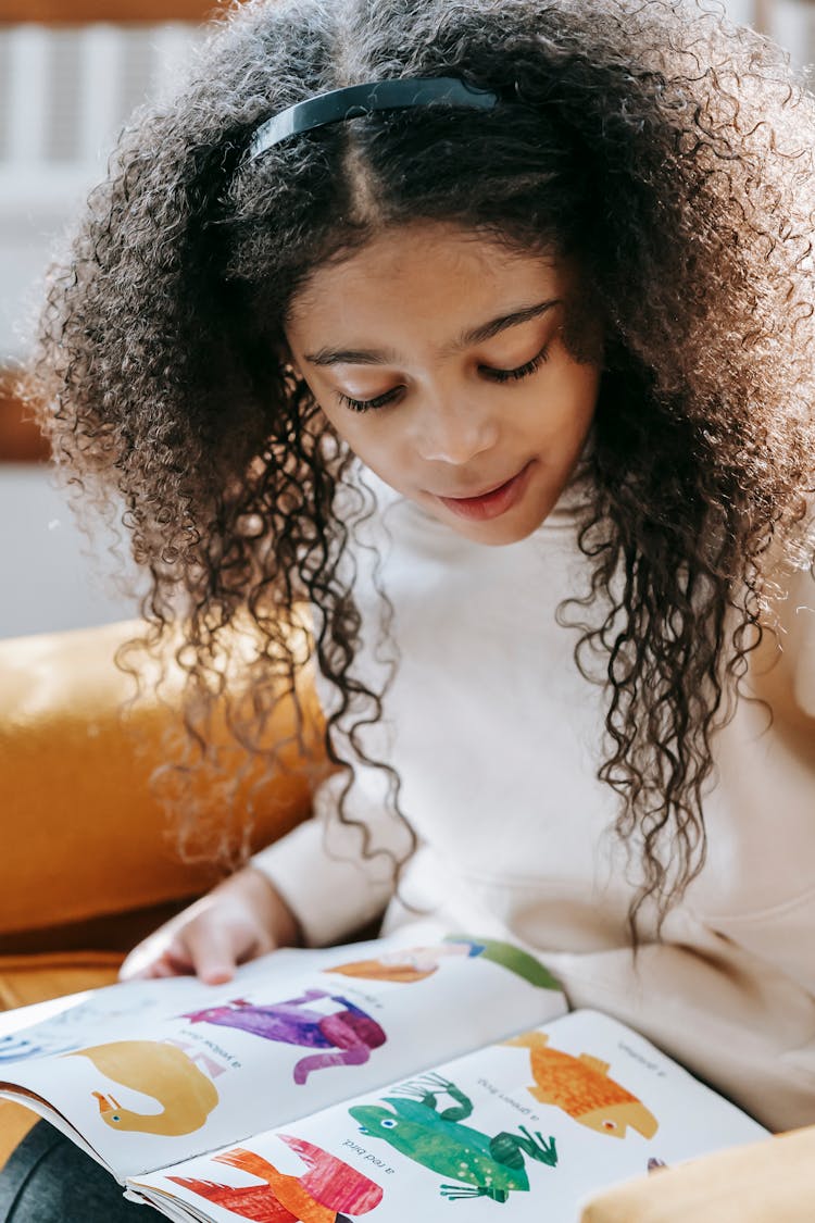 Black Girl Looking At Colorful Illustrations Of Animals