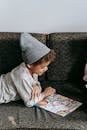 Side view of cheerful African American boy looking at illustration of book with fascinating fairytale