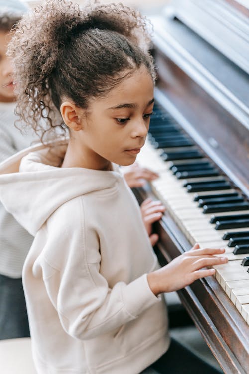 Mujer De Abrigo Beige Tocando El Piano