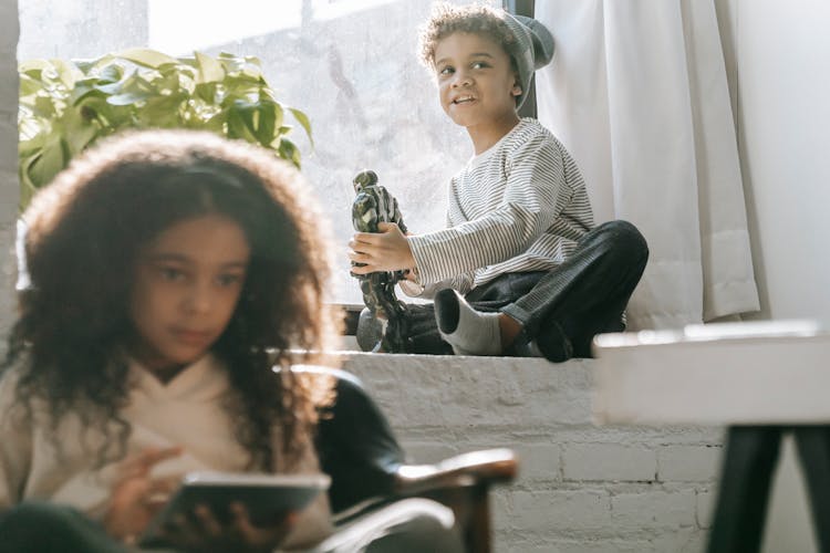 Black Boy With Robot Toy Near Sister With Tablet