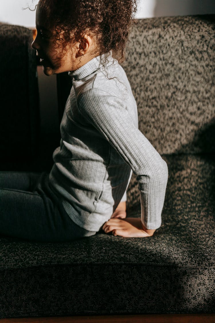 Crop Black Girl Sitting On Couch