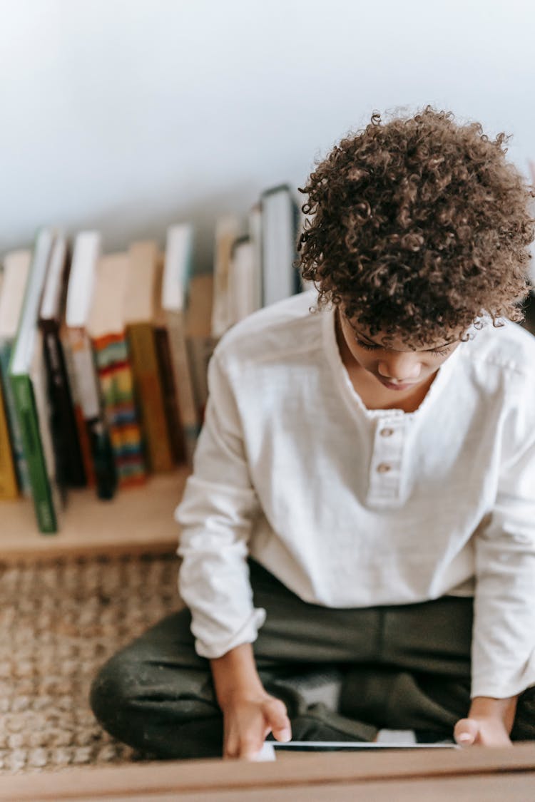 Focused Black Boy Browsing Tablet At Home