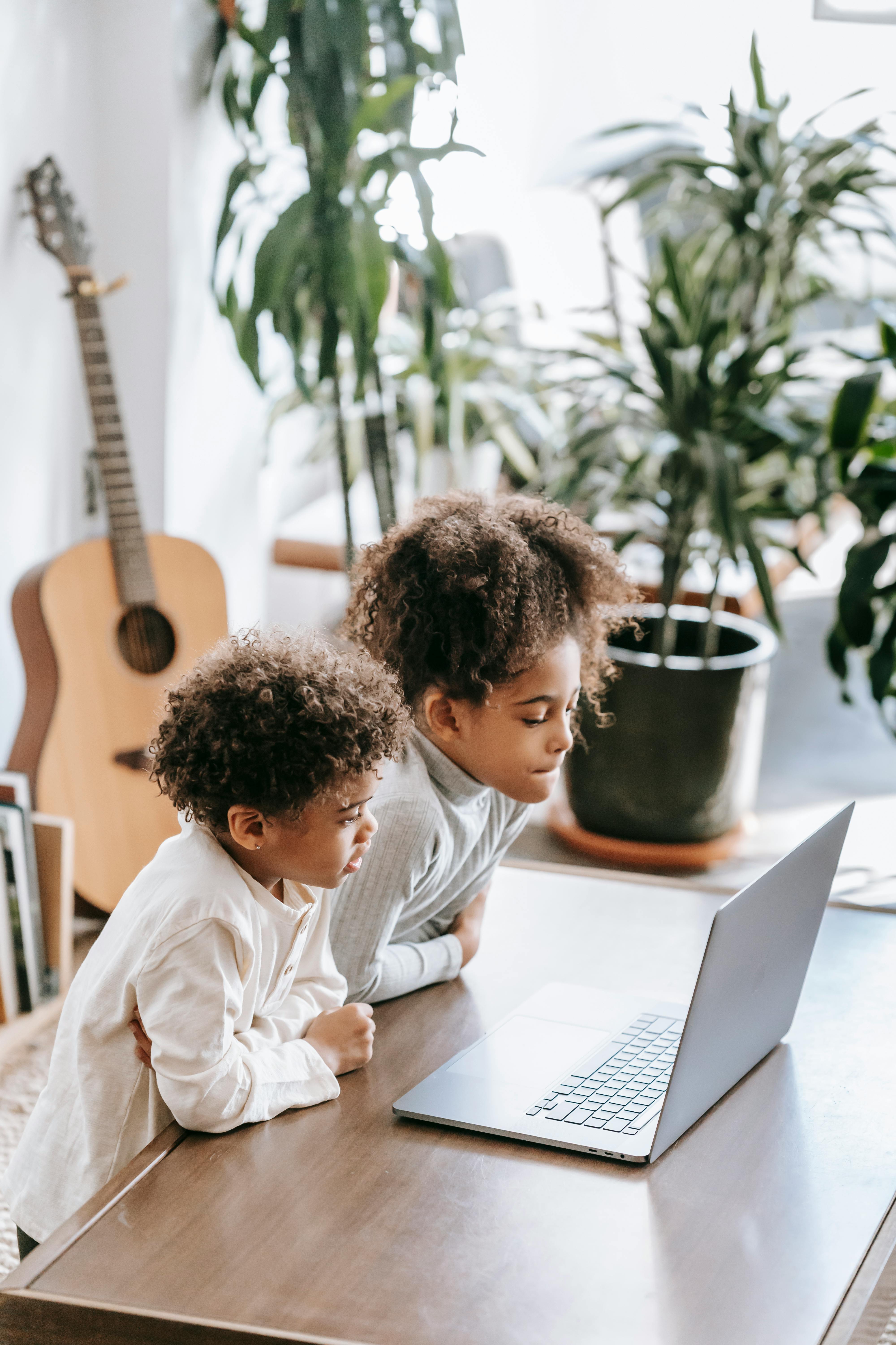 black children using laptop at table