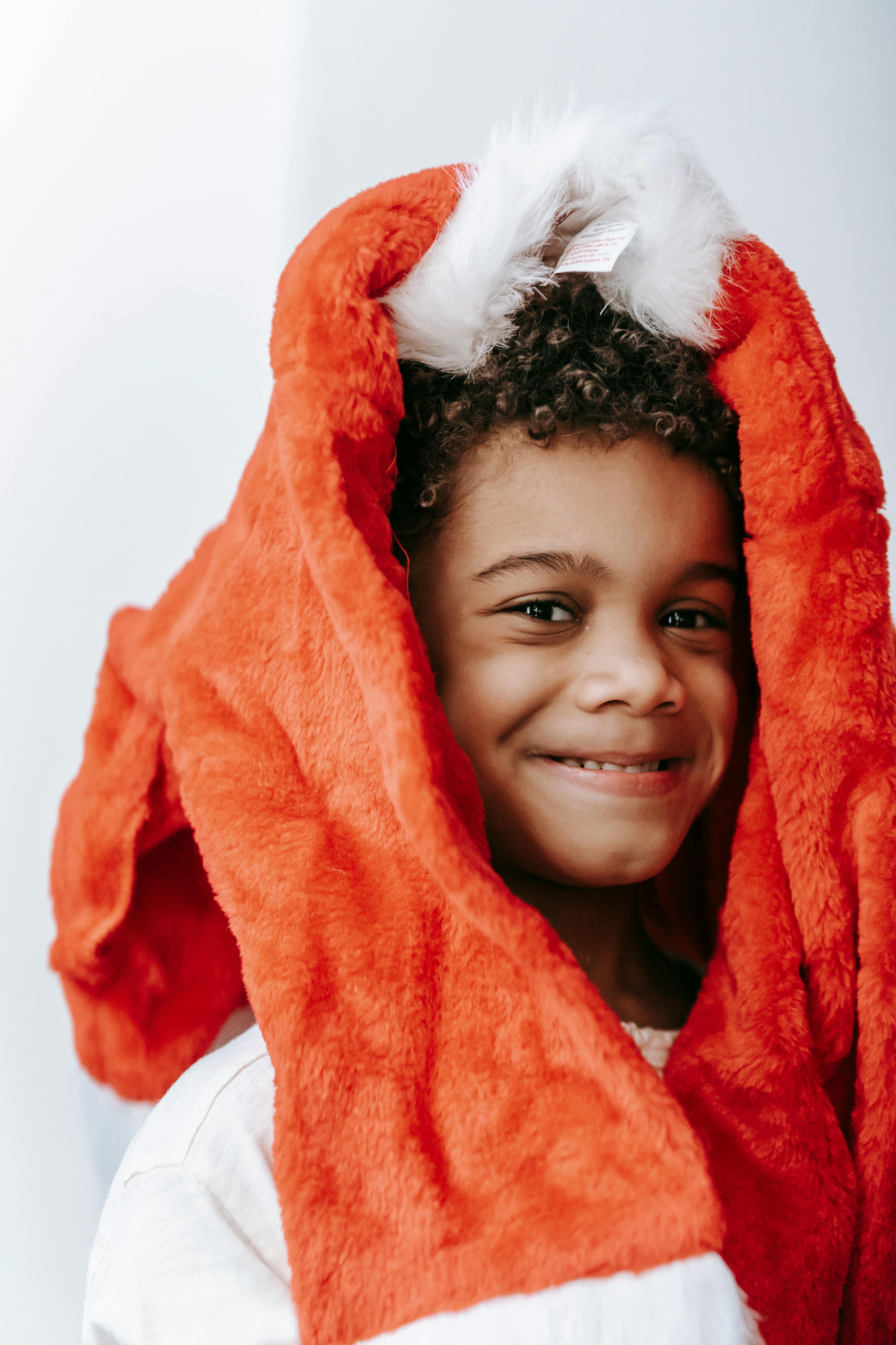 funny black boy with santa claus costume on head