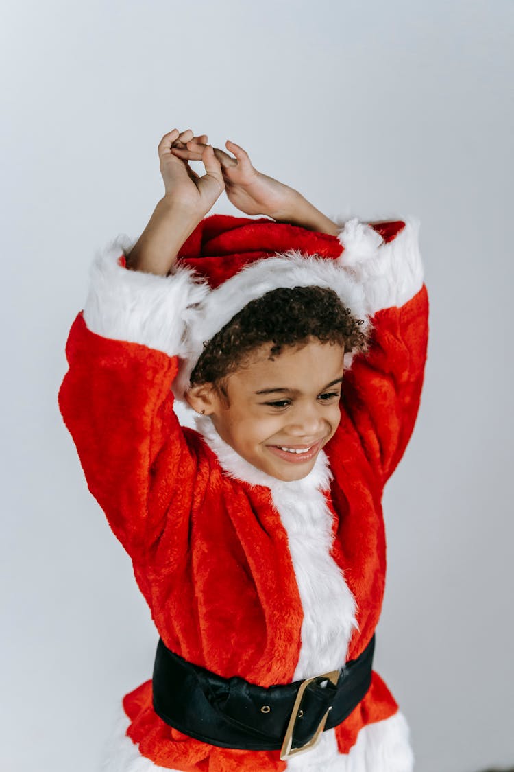 Cheerful Black Boy In Santa Costume Having Fun