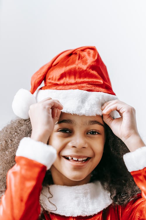 Happy black girl in Santa hat celebrating Christmas holiday