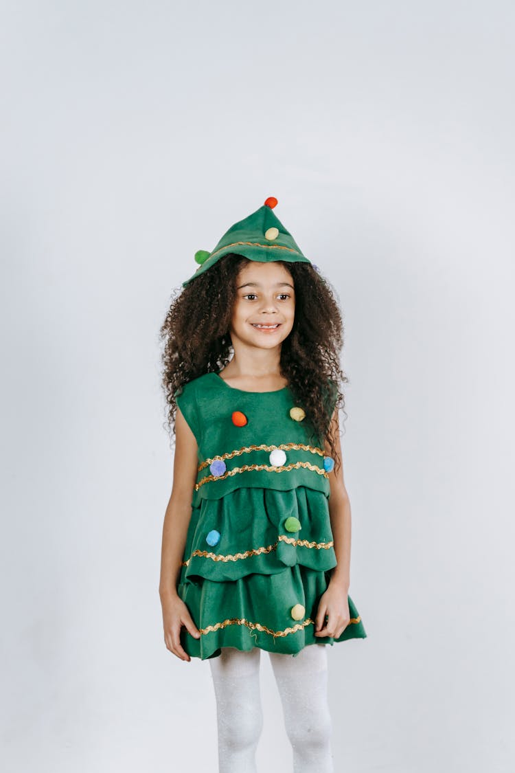 Funny Black Girl In Christmas Tree Costume Standing In Studio