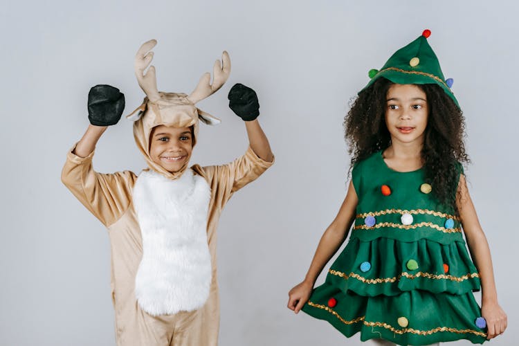 Cheerful Black Kids In Christmas Costumes Playing In Studio