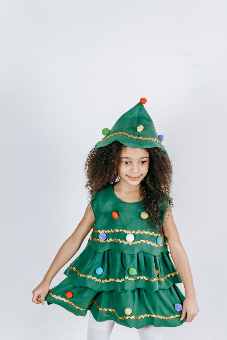 Glad Black Girl In Christmas Tree Costume In Light Studio