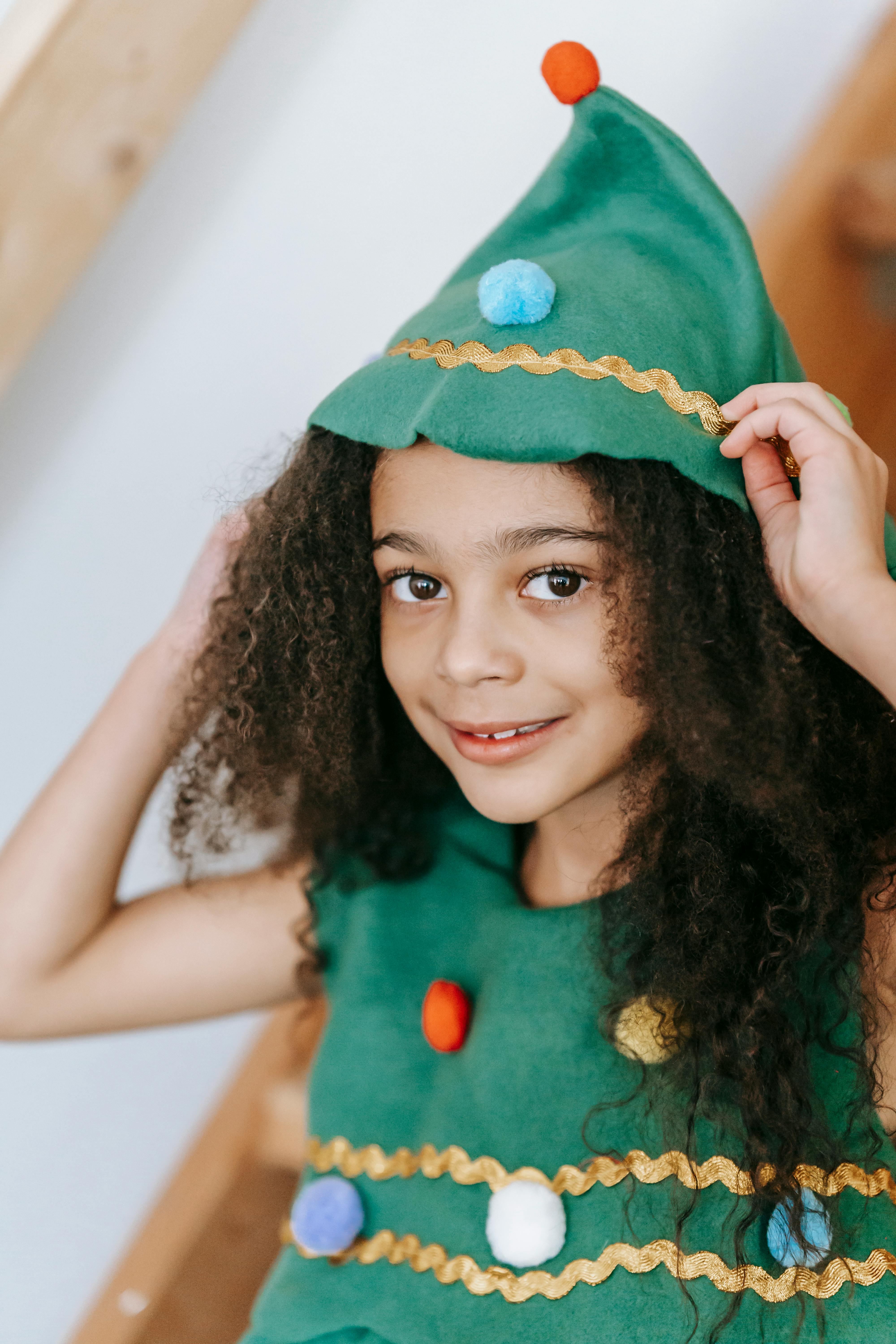 Smiling black girl in Christmas tree costume with headwear · Free Stock Photo