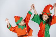 Cute black children in elf outfits on white background