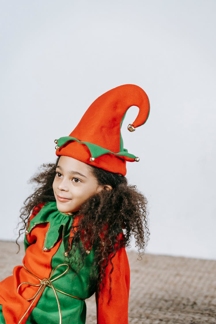 Funny Little Black Girl In Bright Costume Of Elf With Cap