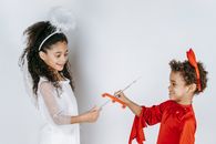 Positive black kids pretending to be angel and devil in studio