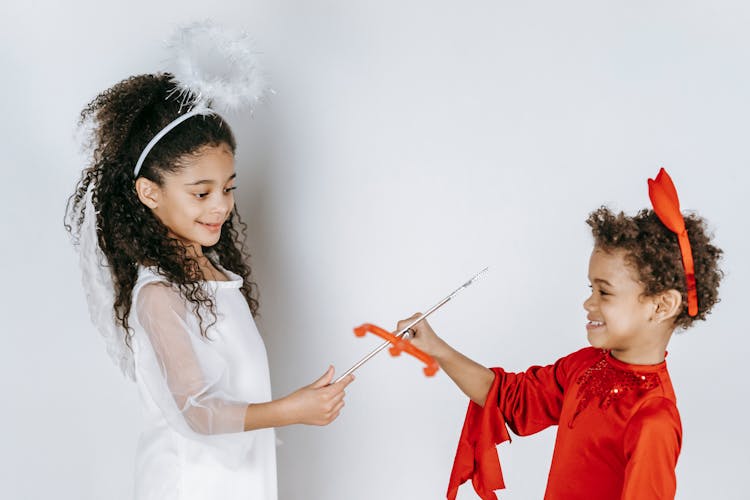 Positive Black Kids Pretending To Be Angel And Devil In Studio