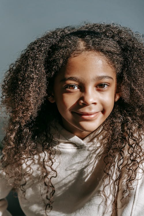 Charming little girl with plant at home · Free Stock Photo