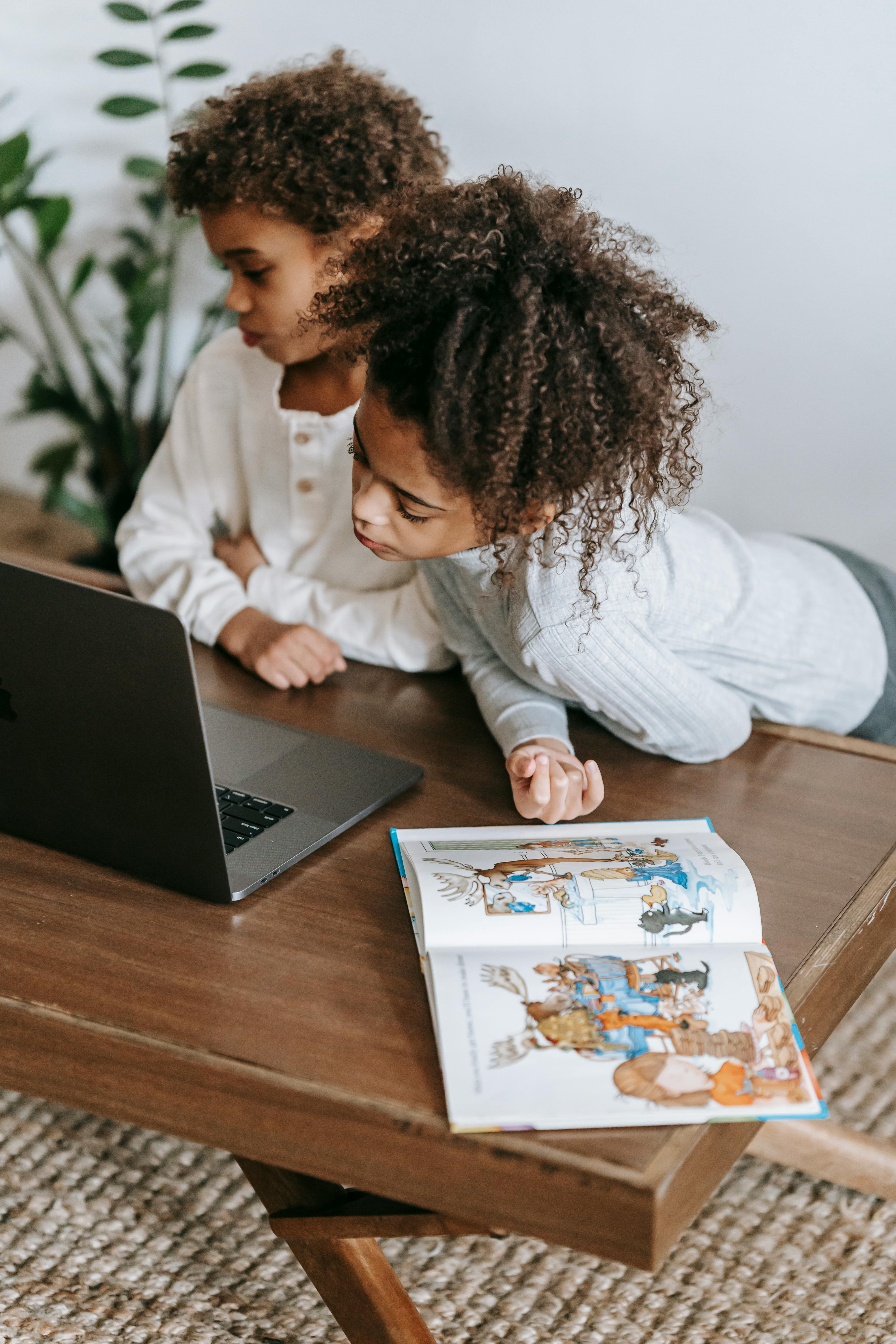 calm black children sharing laptop at home