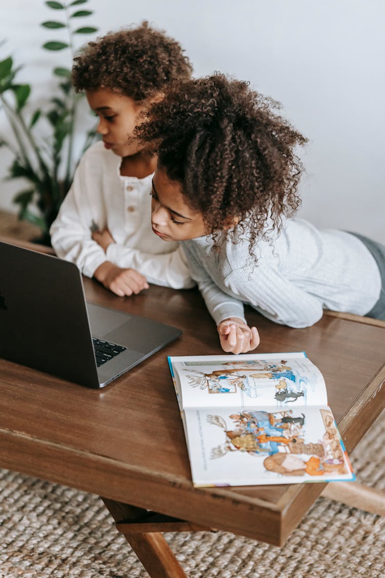 Calm Black Children Sharing Laptop At Home