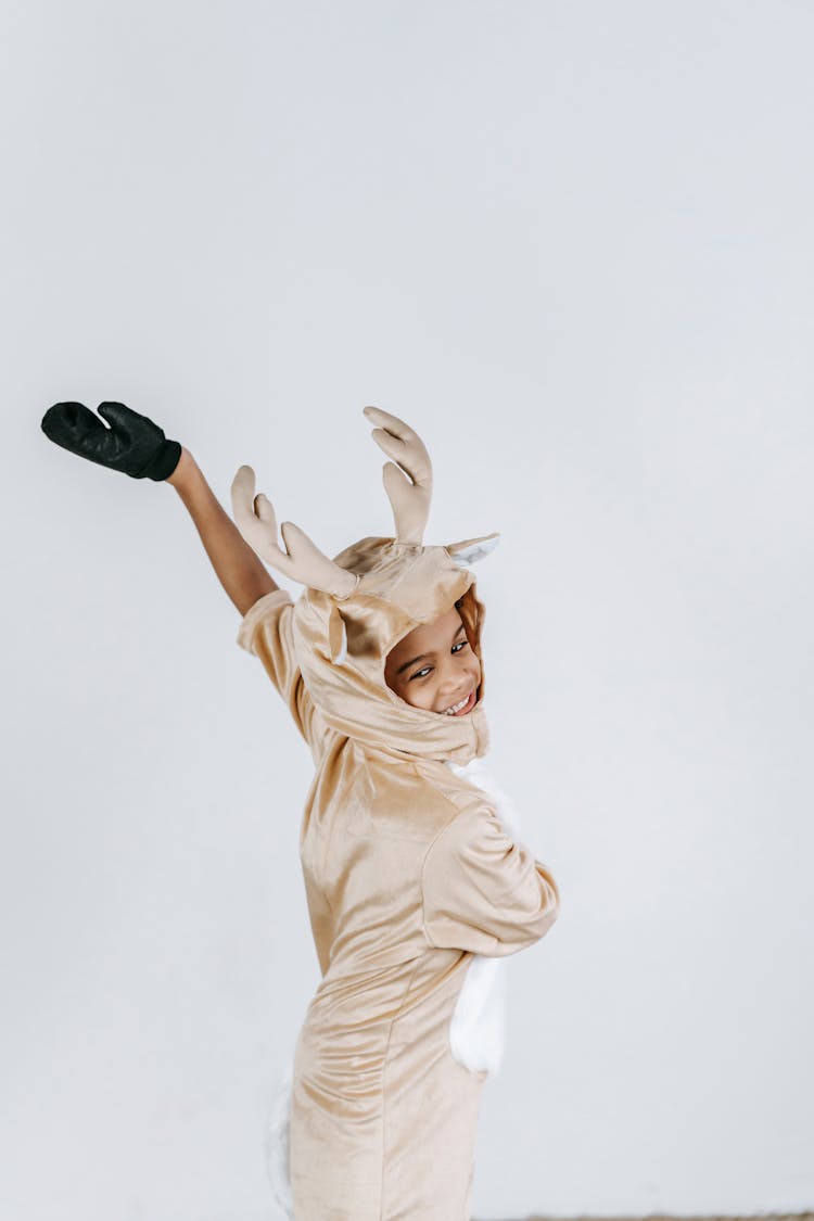 Positive Black Boy In Reindeer Costume Dancing