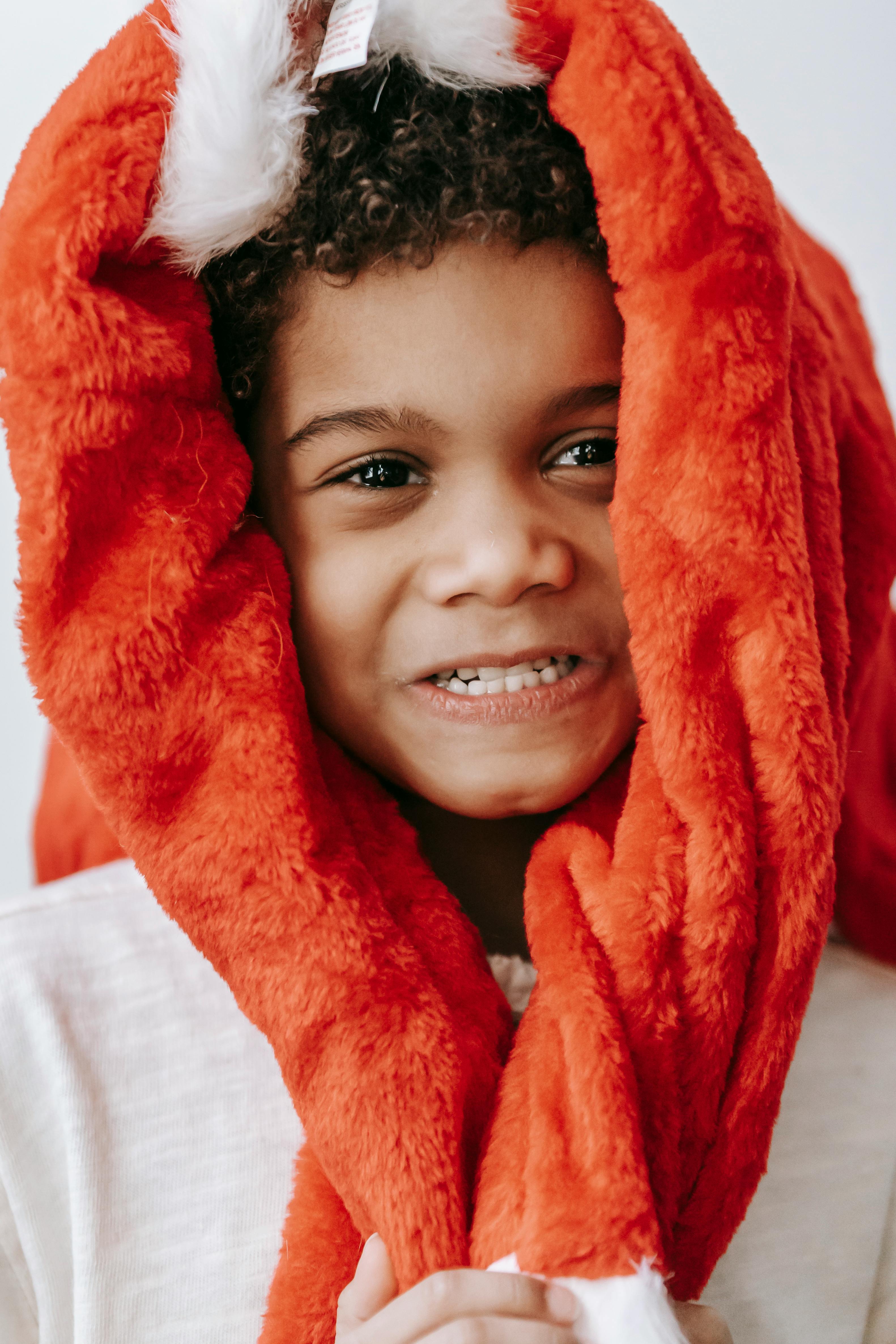 cheerful funny black boy wearing santa costume