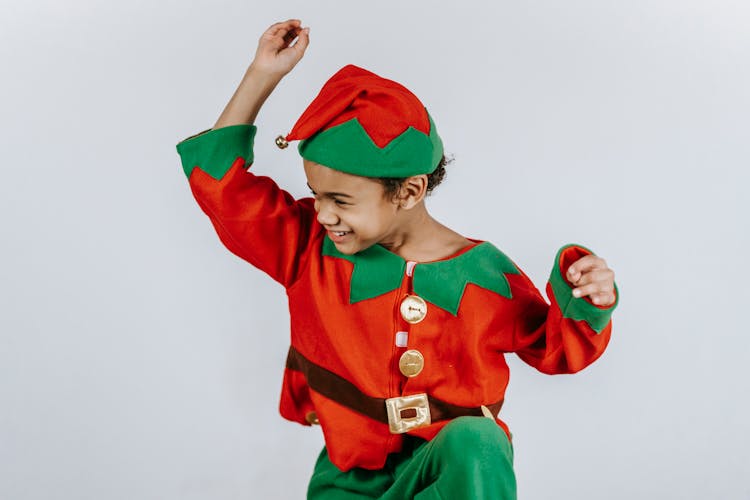 Positive Black Boy In Bright Costume Of Elf Dancing