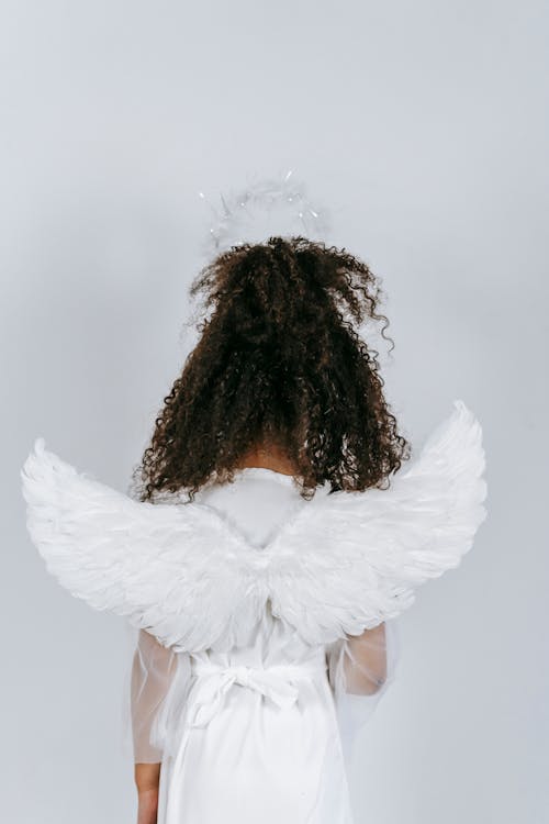 Free Black girl in costume of angel with tender white wings Stock Photo