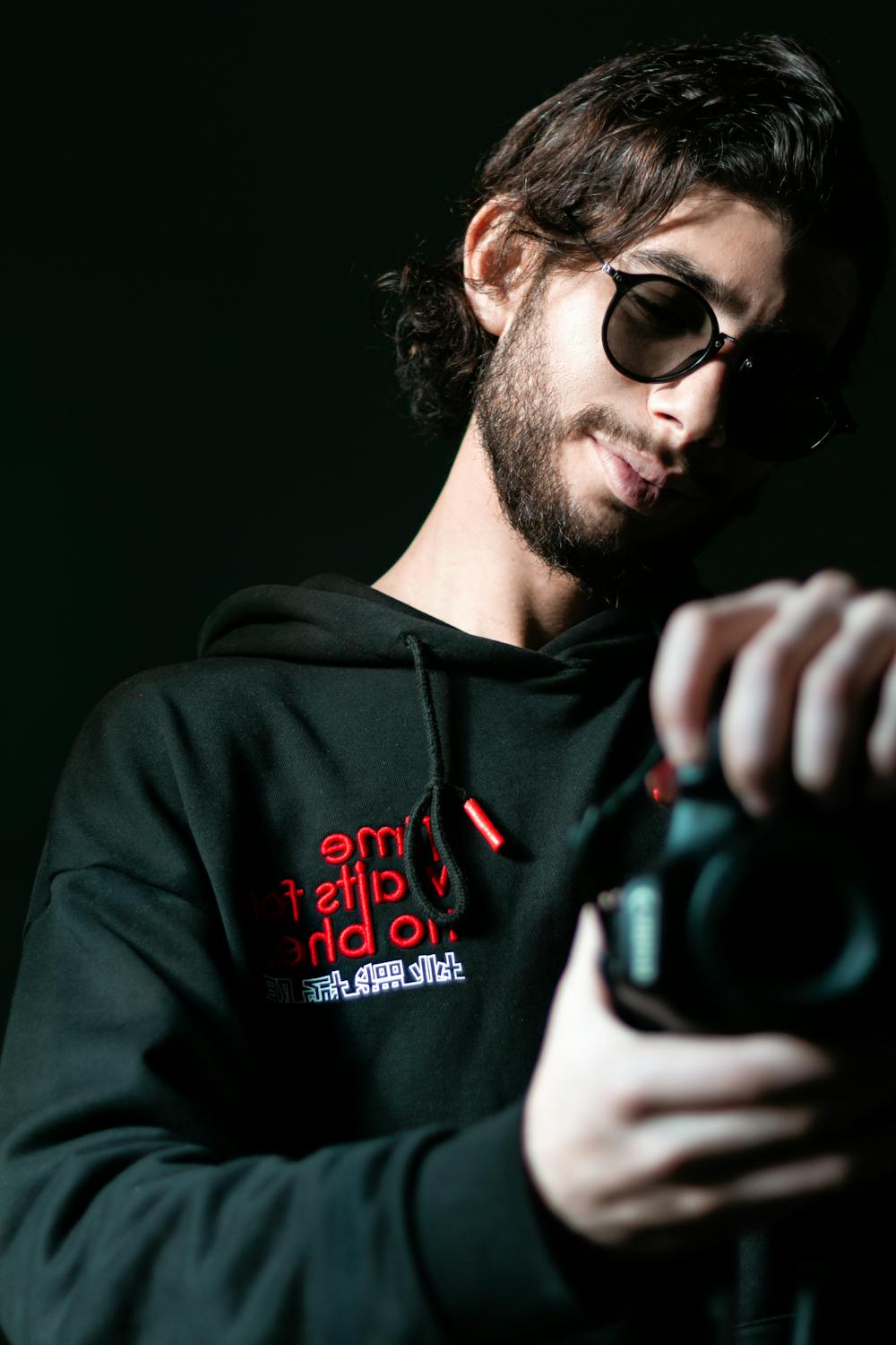 Man in Black and Red Hoodie Holding Black Dslr Camera · Free Stock Photo