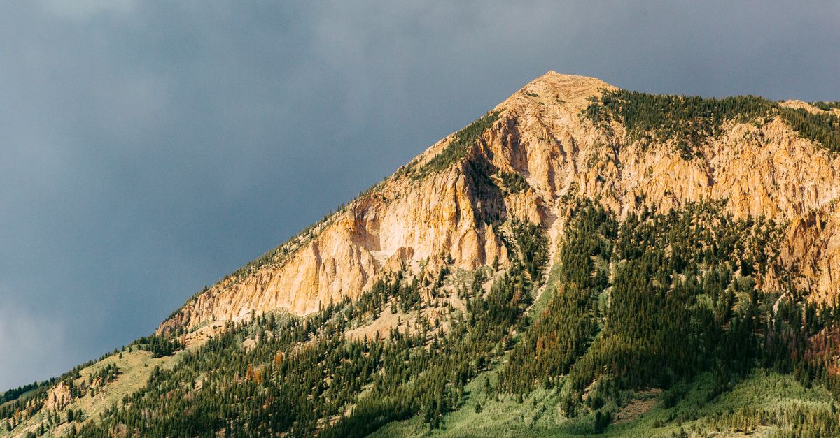 A captivating view of a mountain peak in Crested Butte, CO, with vibrant colors at sunset.