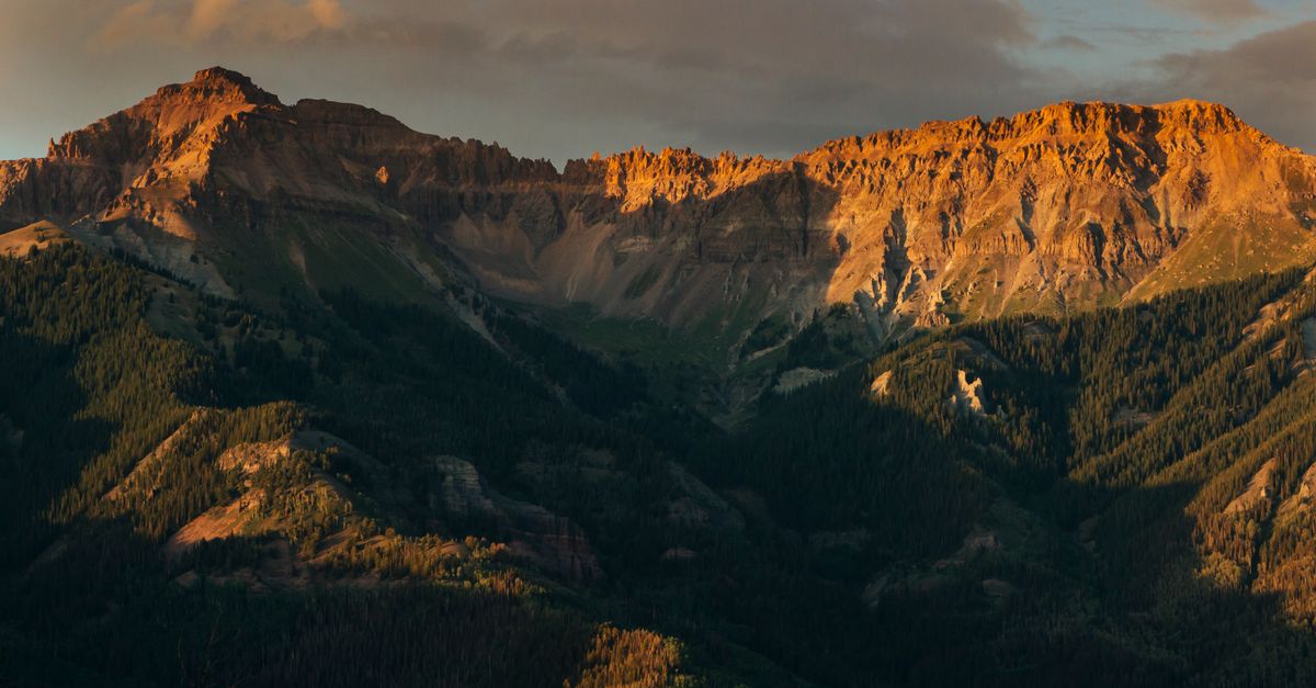 Stunning view of the Rocky Mountains during a warm sunset in Telluride, Colorado.