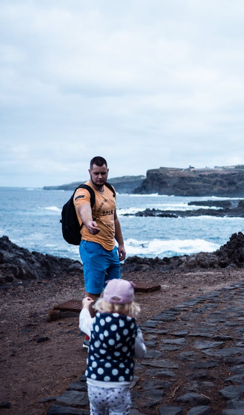 Man Walking with Child on Seashore