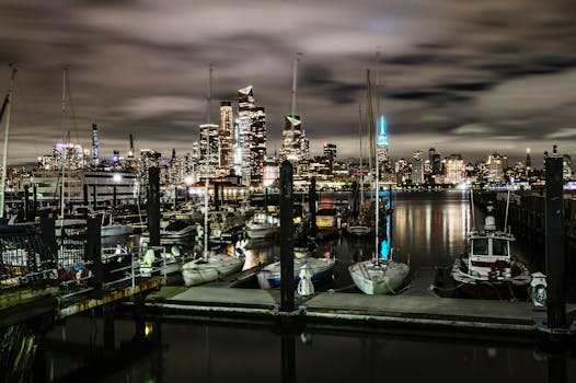 A stunning view of the New York City skyline with boats docked at the harbor during the night.