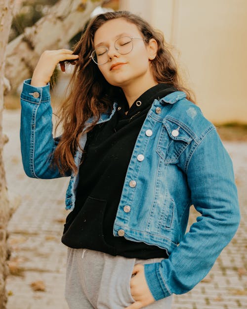 Young Girl in Blue Denim Jacket Holding Her Hair