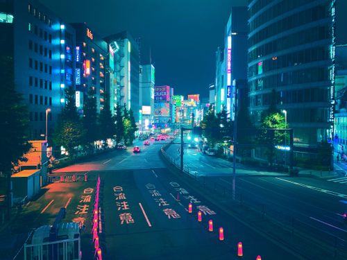 Free Vibrant Tokyo cityscape at night with neon lights and bustling streets, captured from above. Stock Photo