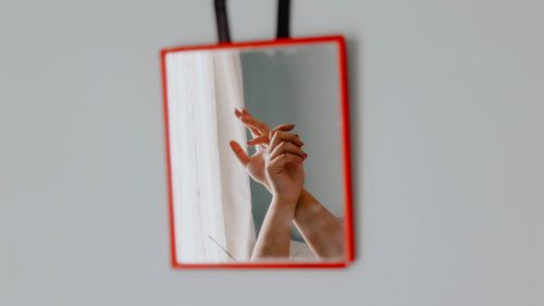 Free A pair of hands gracefully reflected in a mirror, creating a thoughtful composition. Stock Photo