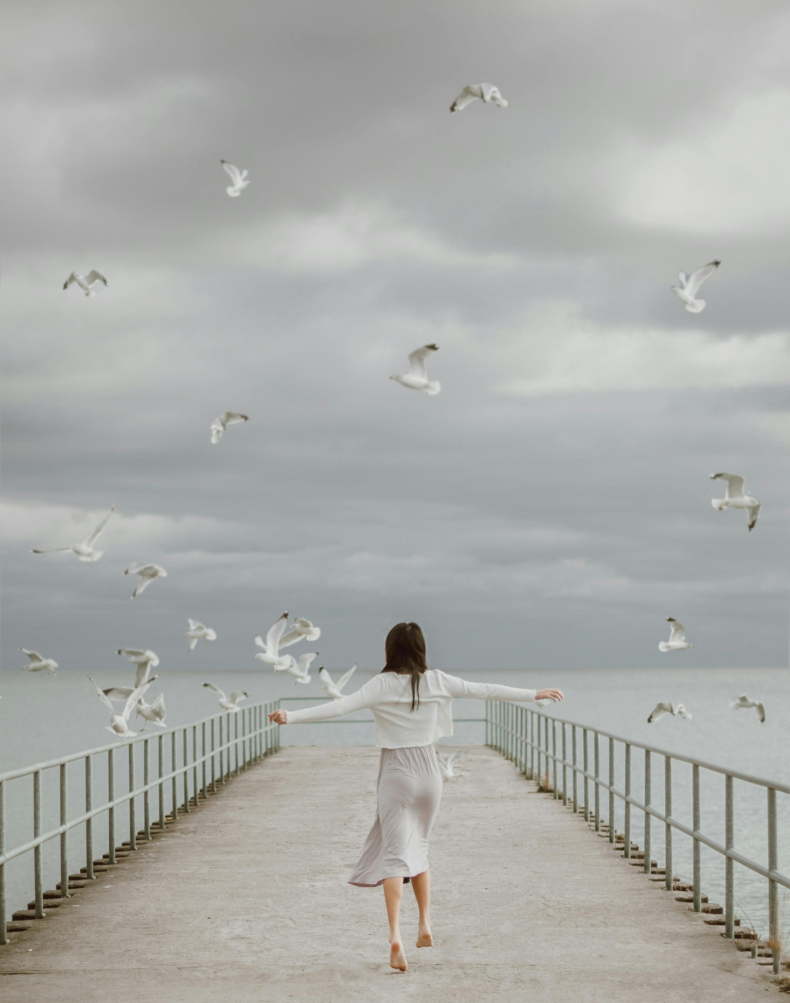 faceless barefoot female traveler on embankment against sea