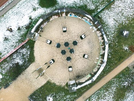 Drone shot of a circular structure in a snowy landscape in Weißenfels, Germany.