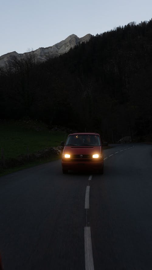 Car driving along asphalt road in mountainous terrain