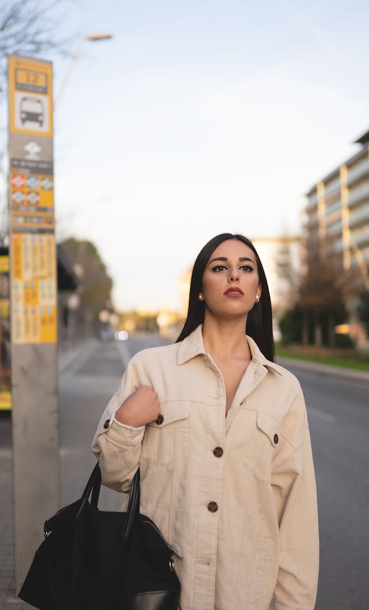 Confident Young Woman Standing On Bus Stop And Looking Away